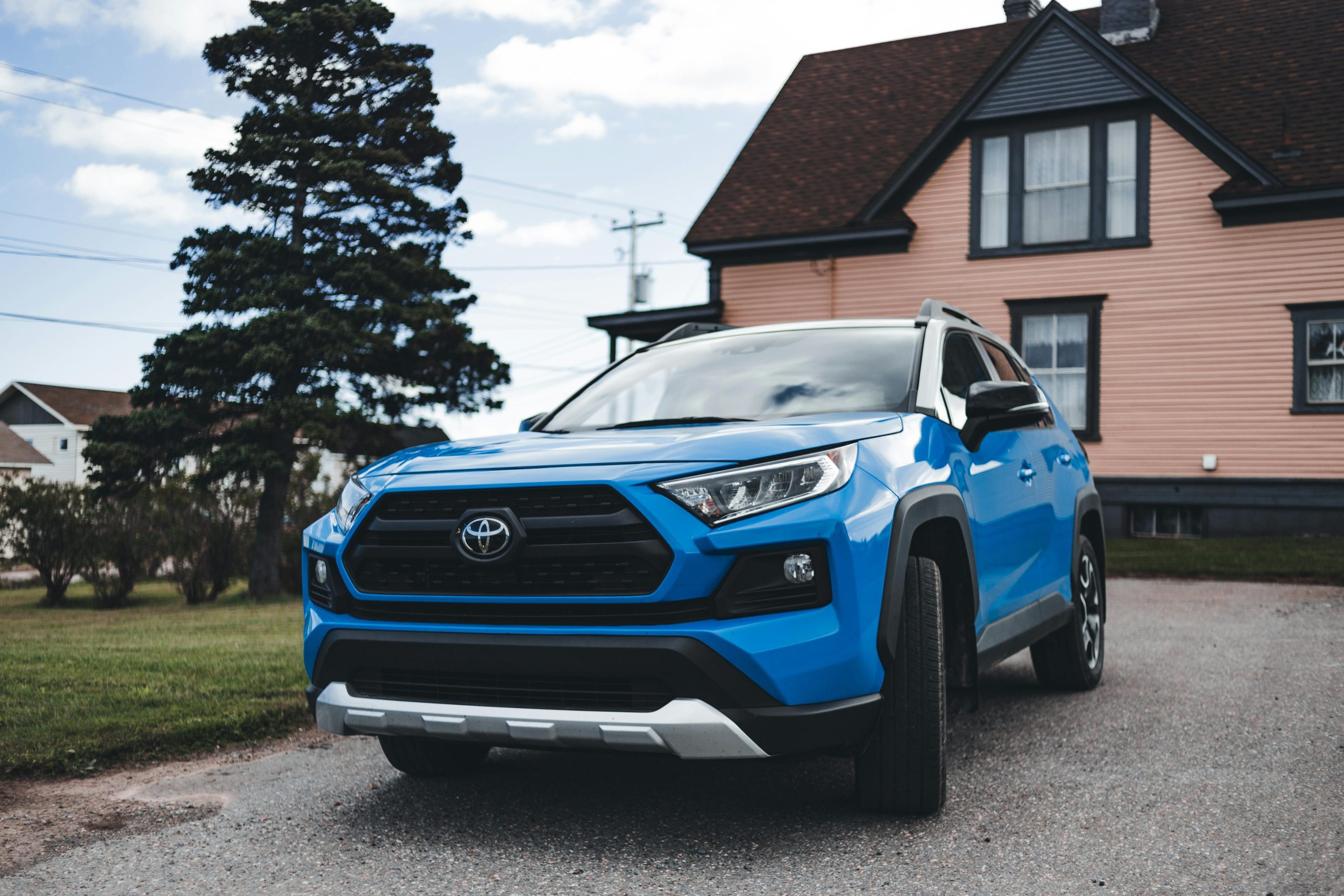 Blue Toyota SUV parked outside a house, showcasing modern automotive design in a suburban setting.